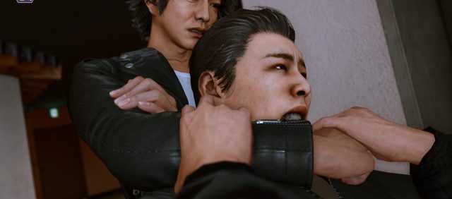 Yagami restraining a man with a choke-hold