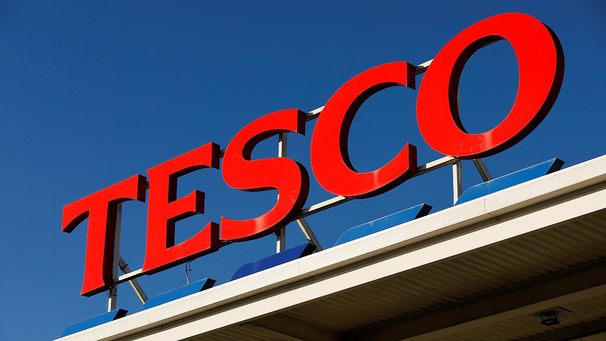 Tesco-Logo mit einem klaren, blauen Himmel dahinter.
