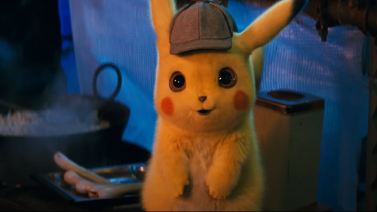 one of the best movies based on games, Pokemon detective Pikcahu. Pikachu looks cutely at the screen with a brown hat on. Behind them in the scene is food being cooked.