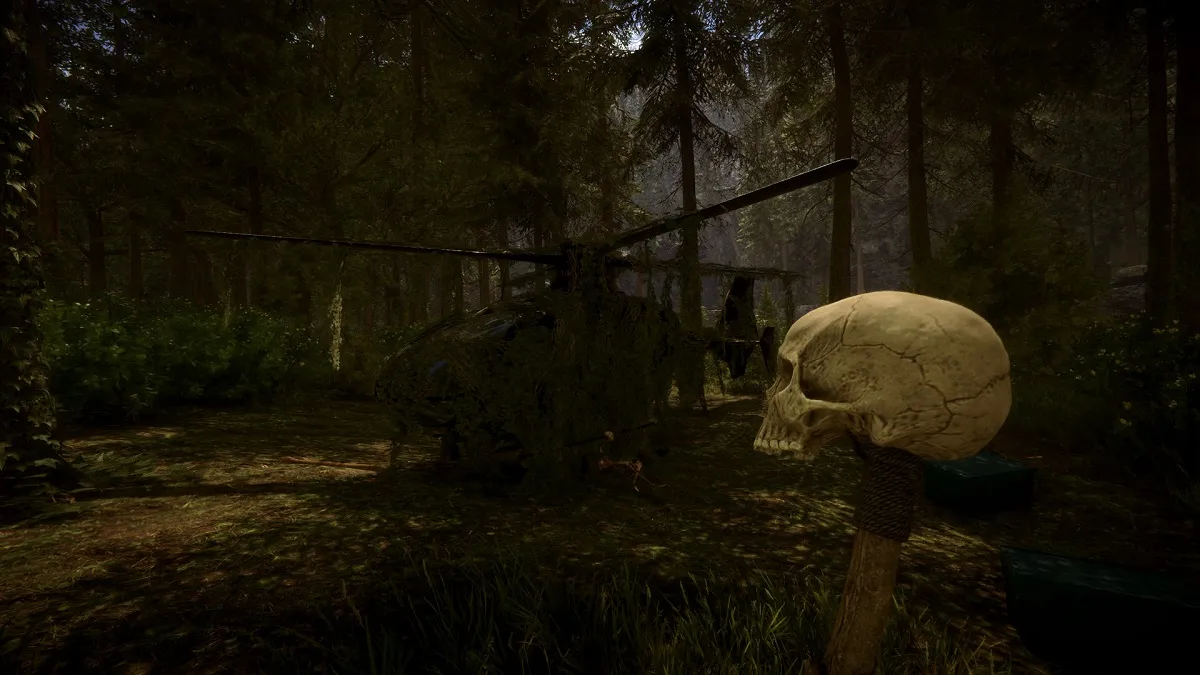 Sons of the Forest: a downed helicopter cover in foliage with a skull totem in the foreground.