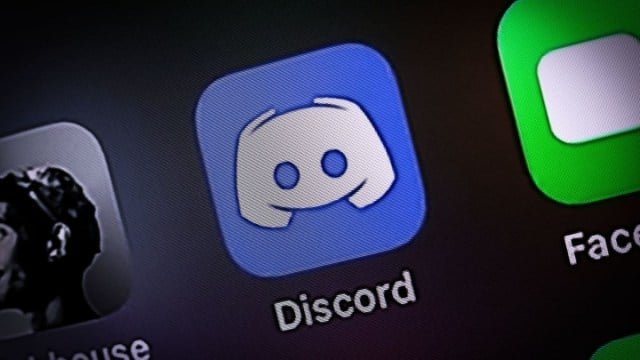 Close-up of the Discord icon on a phone screen, next to FaceTime.