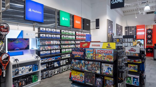 The inside of a GAME store in the UK, showing shelves of PlayStation and Xbox titles.