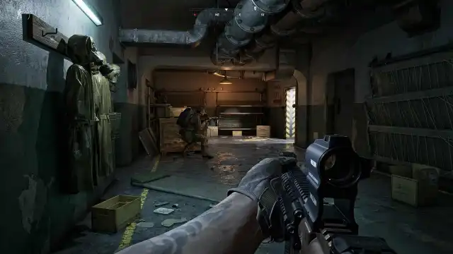 Two Gray Zone Warfare players walking down a dark tunnel, aiming towards an open doorway. 