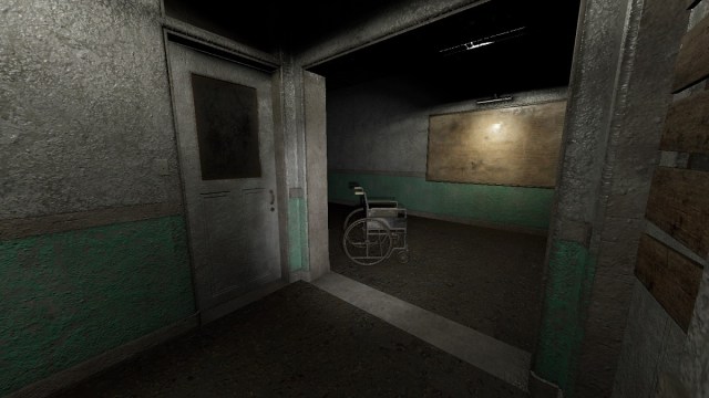 Phasmophobia: a creepy corridor with an abandoned wheelchair nearby.