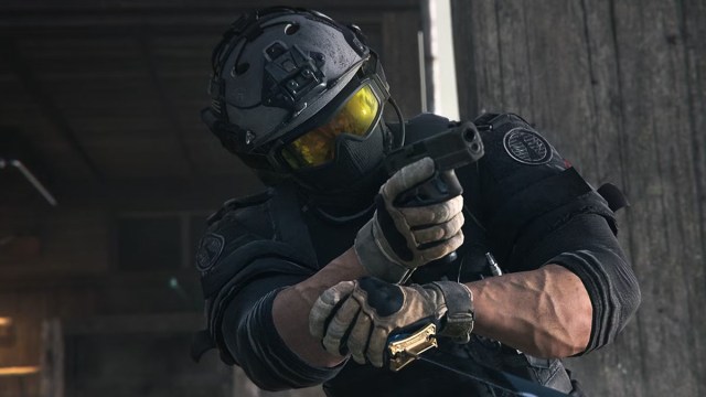A Warzone player aiming their pistol, wearing yellow goggles and a grey helmet.