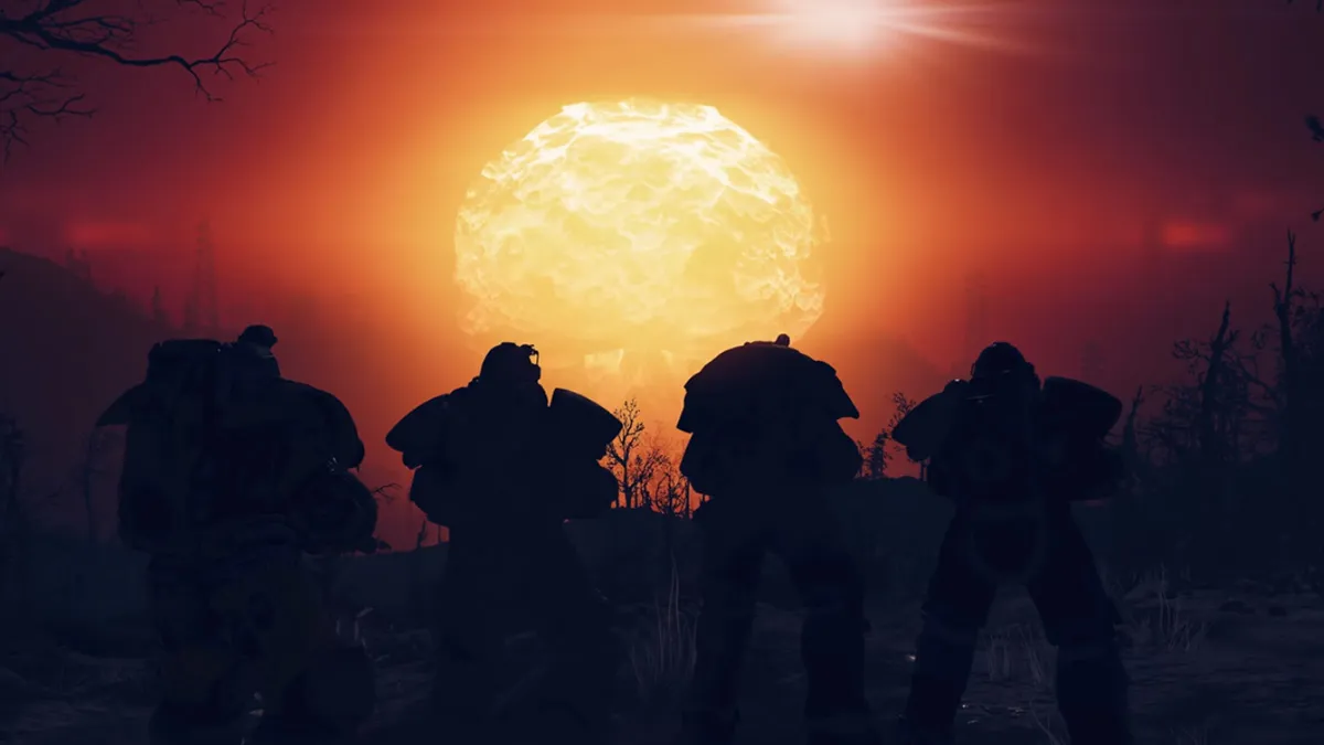 Four Fallout 76 characters standing in front of a nuke going off in the distance.