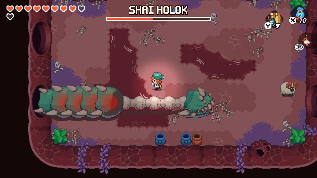 Nia stands above a giant worm named Shai Holok that's missing half of its body.