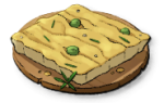 A square chunk of focaccia on a round wooden plate