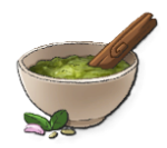A white bowl with pesto in the middle with a wooden stick