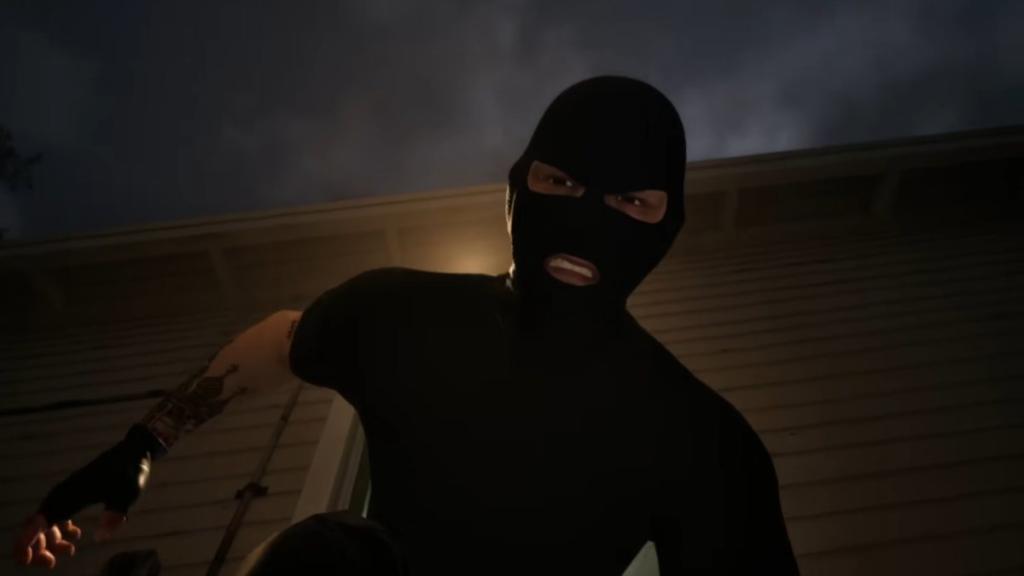 Kidnapper in all black and masked, looking down at Simon