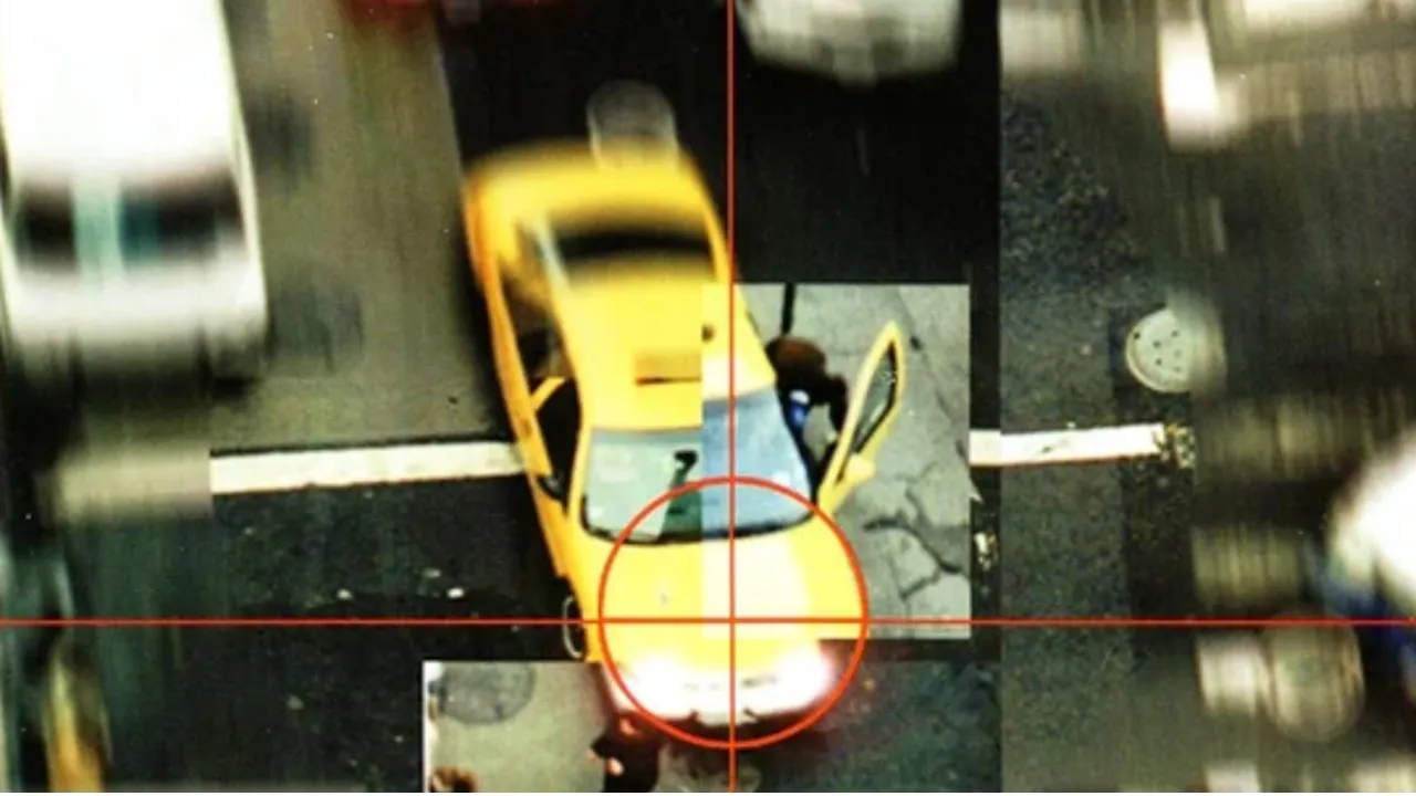 An excerpt of GTA 2's cover art showing a taxi cab being stolen with a red crosshair superimposed on its hood.