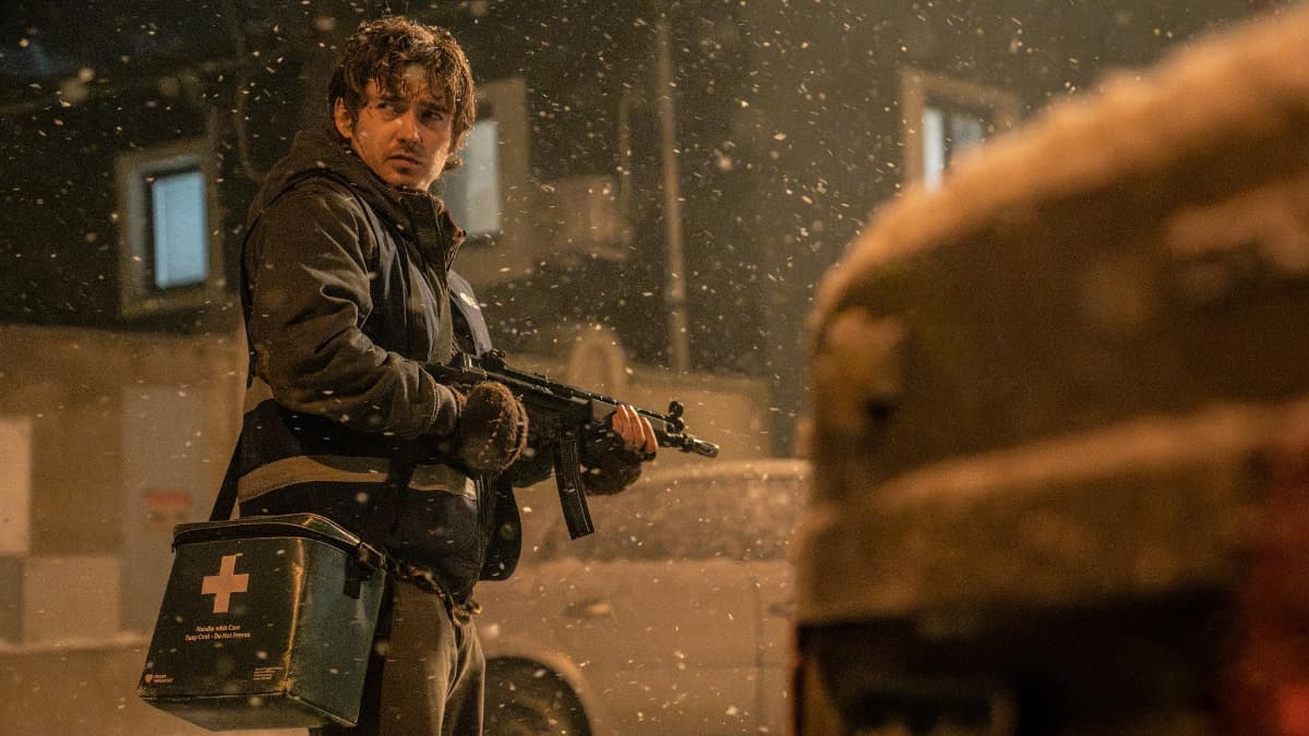 Bryan holding a gun in town in Zach Cregger's Resident Evil movie.