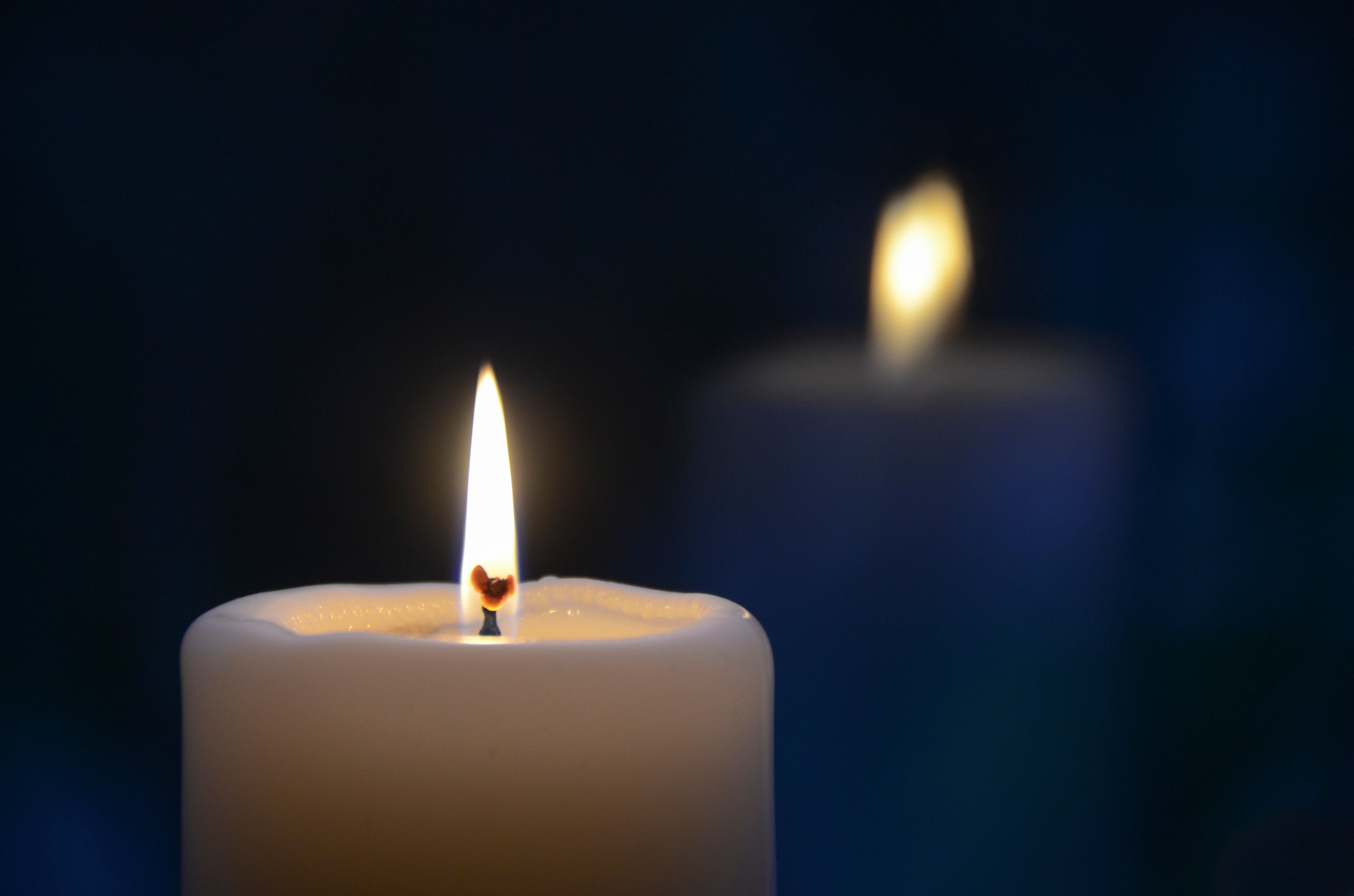 Close-up of a burning candle with a soft glow, creating a tranquil atmosphere.